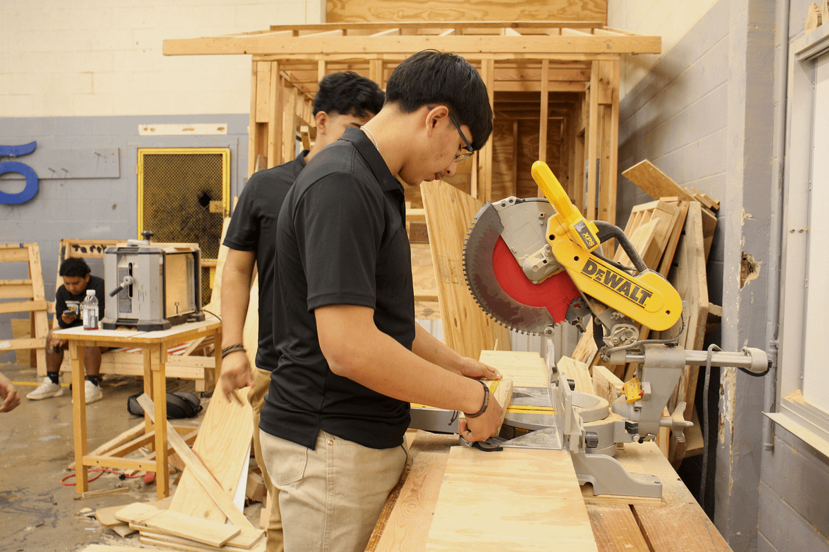 Construction students helping each other out with the set up that they are preparing for their assignment.